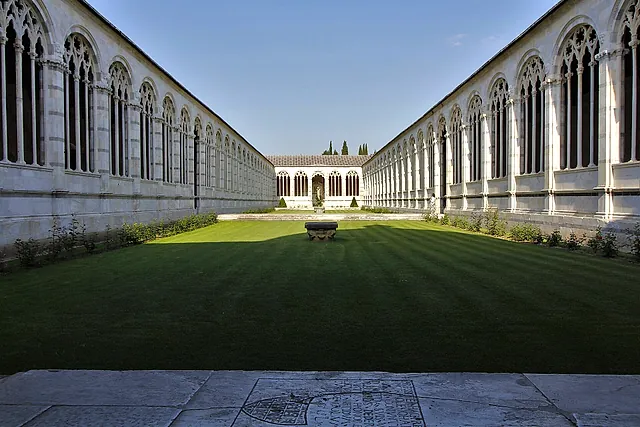 The long white marble arcades of the Camposanto Monumentale on either side of the grass courtyard