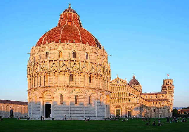 The red-tiled dome of the Baptistery in warm evening light, with the Cathedral and the Leaning Tower behind it